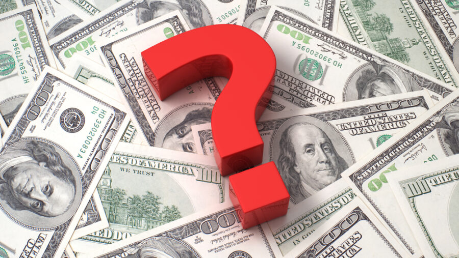 Red question mark over spread American $100 bills.