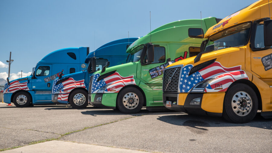 ShipEX trucks with military wraps parked in a row.