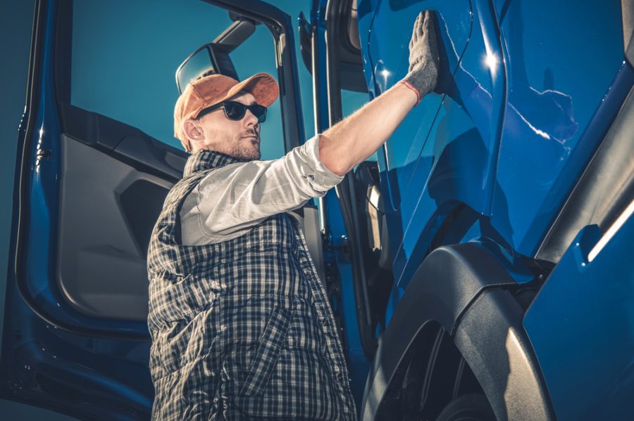 Truck driver inspecting semi truck door