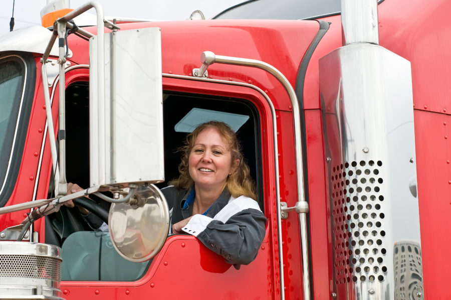 Woman truck driver driving a red semi truck