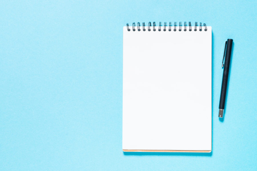 Blank white notebook on blue background