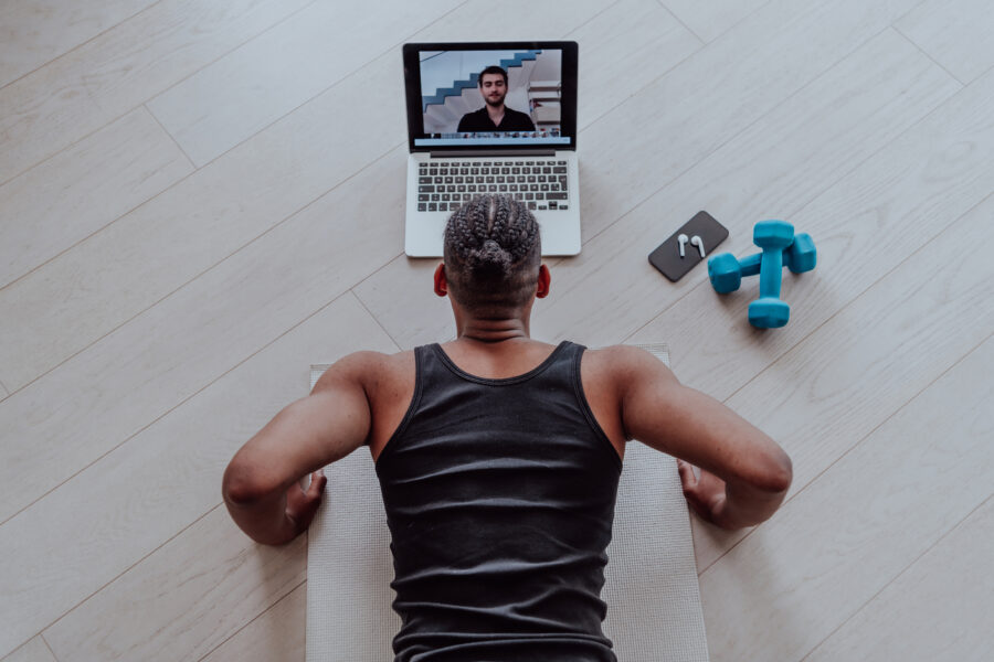 Man doing home workout in front of laptop