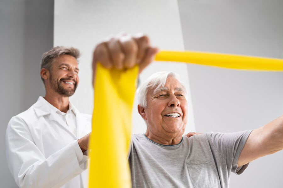 Old man doing physical therapy with doctor