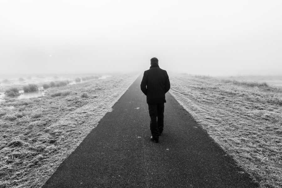 Man walking down desolate road