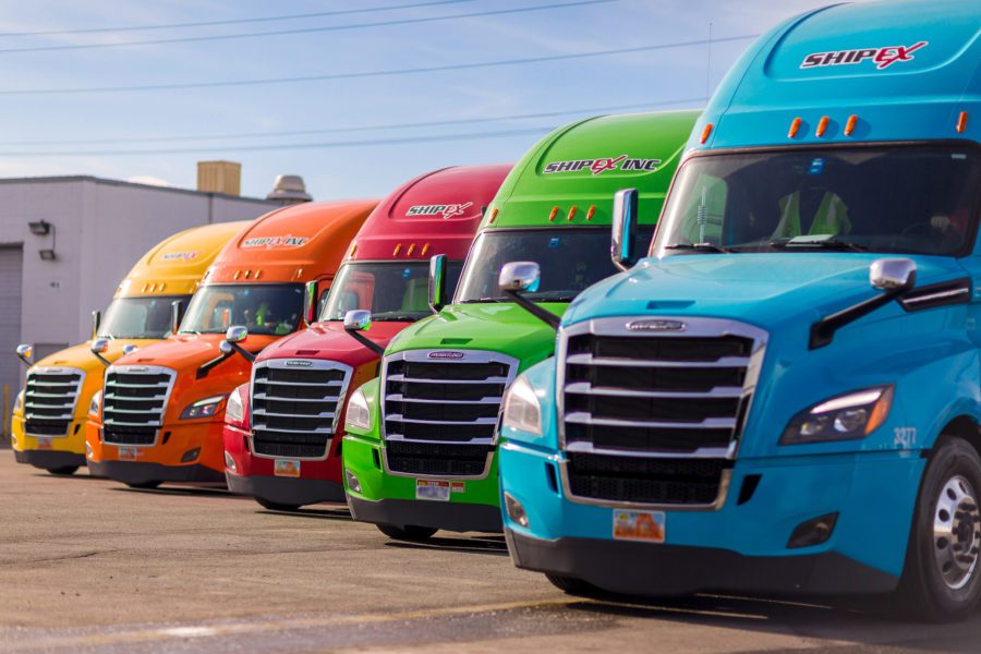 Colorful ShipEX semi-trucks parked in a row.