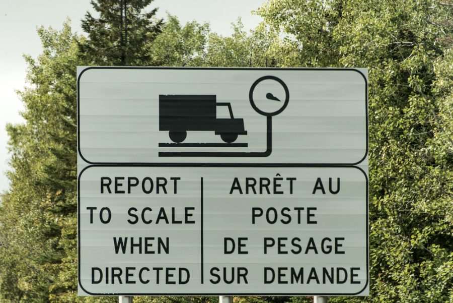 road sign instructing how to use a weigh station