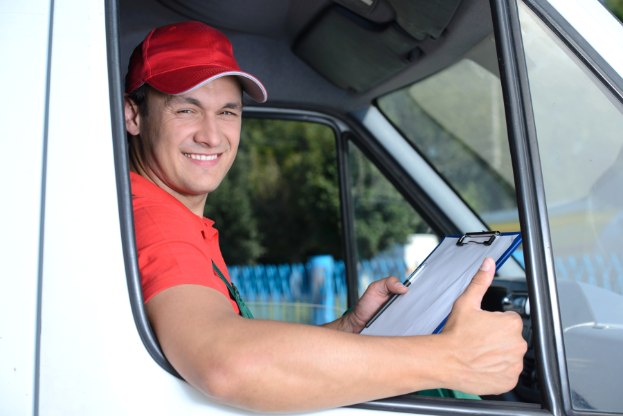 delivery driver sitting in truck with a check list giving a thumbs up