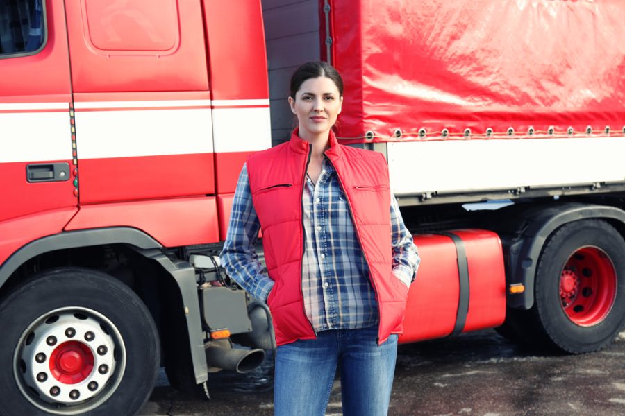 Young female driver near big modern truck outdoors