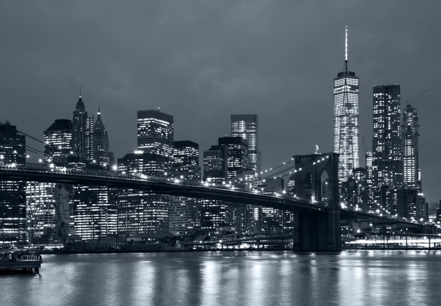 Panoramic view new york city manhattan downtown skyline at night with skyscrapers and brooklyn bridge