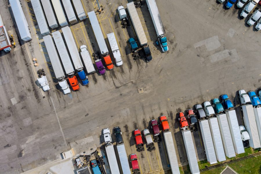 Top view car parking for heavy trucks stop on rest area in the highway trucks stand in a row