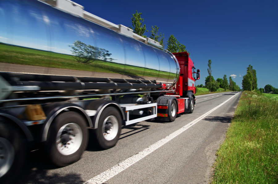 Tanker truck driving down empty road