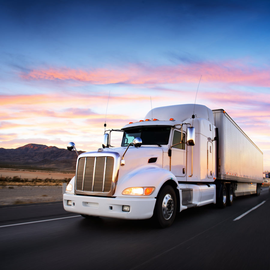 White truck driving down empty road