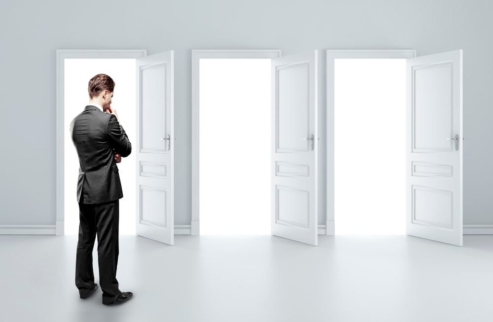 man choosing between three open doors