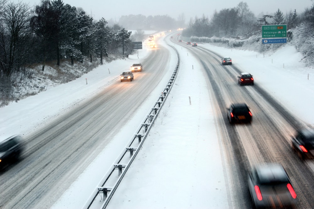 cars driving down snowy highway