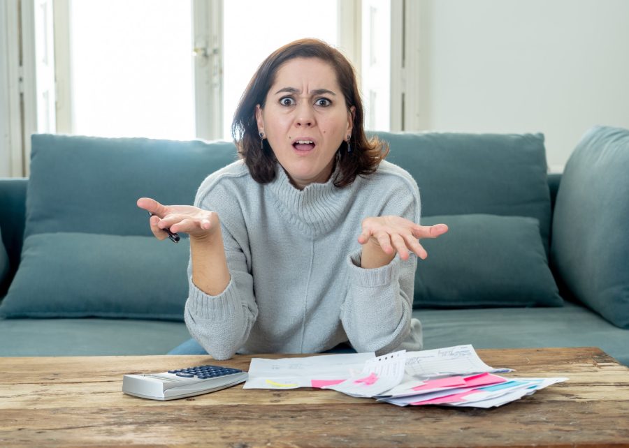 confused woman with paperwork and calculator