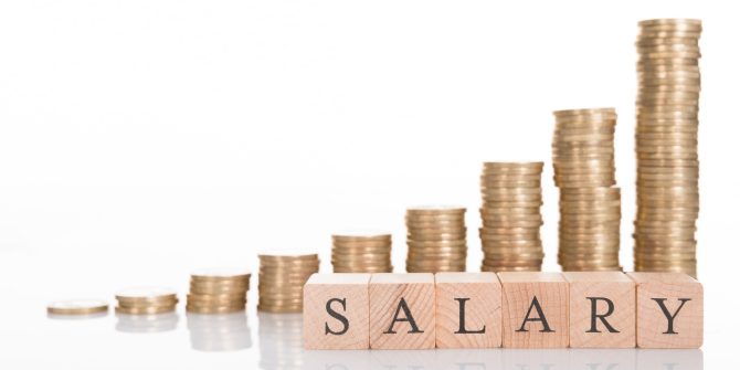 Stacks of coins with salary written on letter blocks